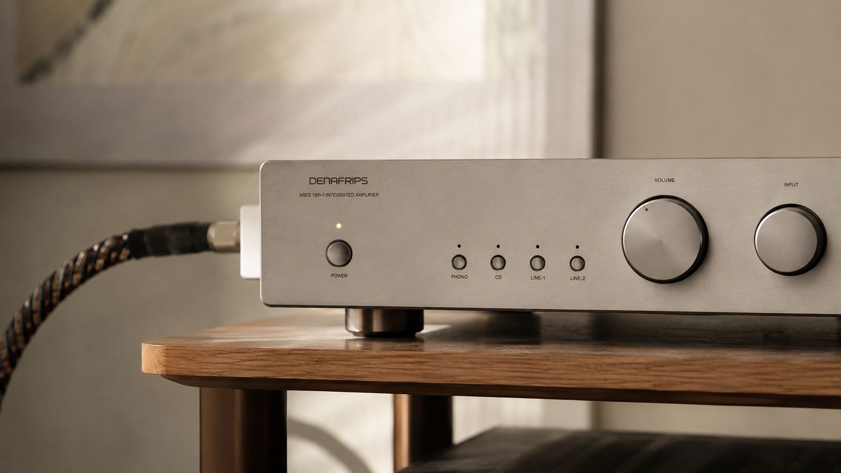 A Denafrips silver integrated amplifier sits on a wooden shelf, featuring volume and input adjustment knobs.