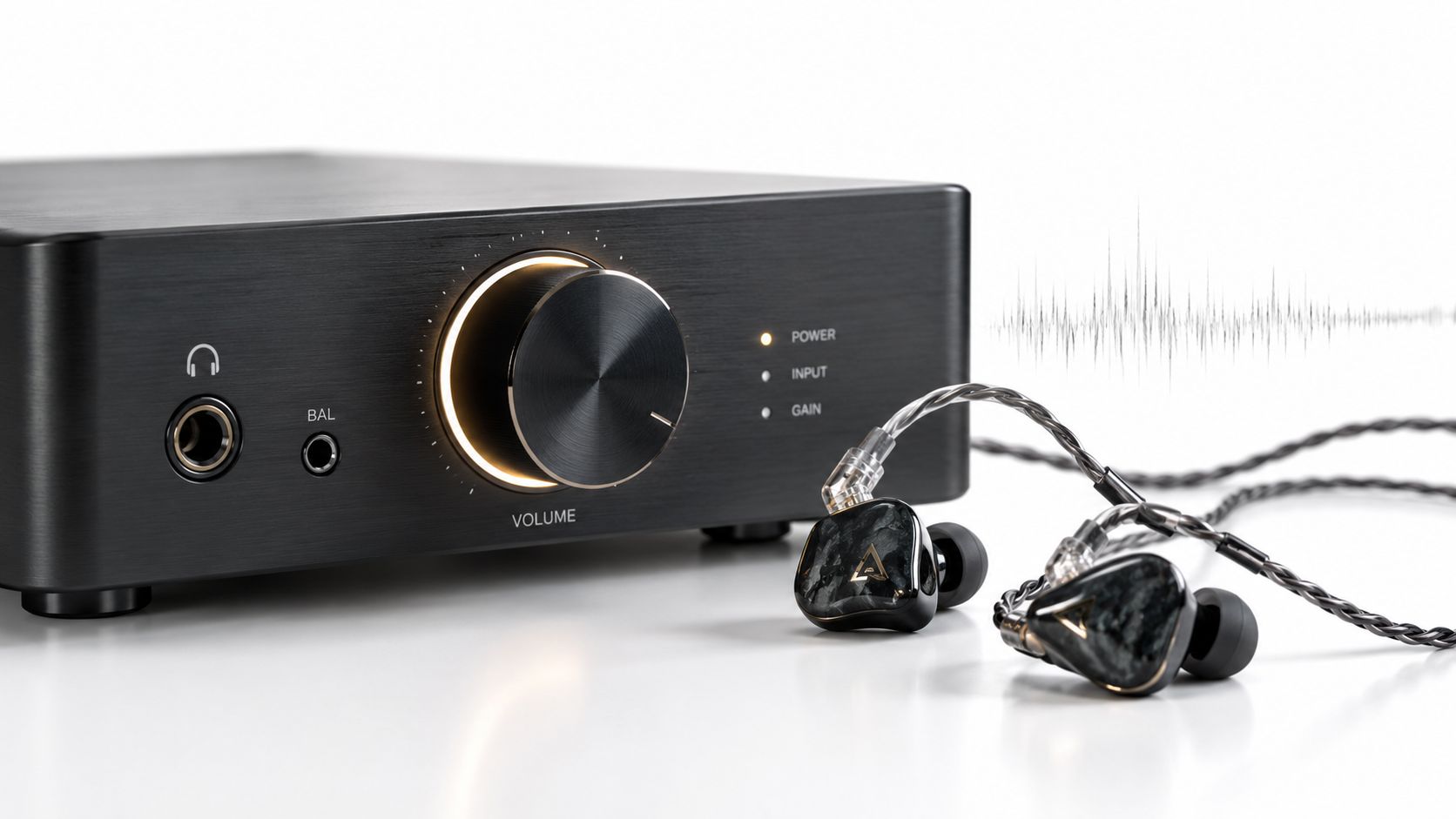 A high-end desktop amplifier for headphones with premium in-ear monitors resting on a white surface.