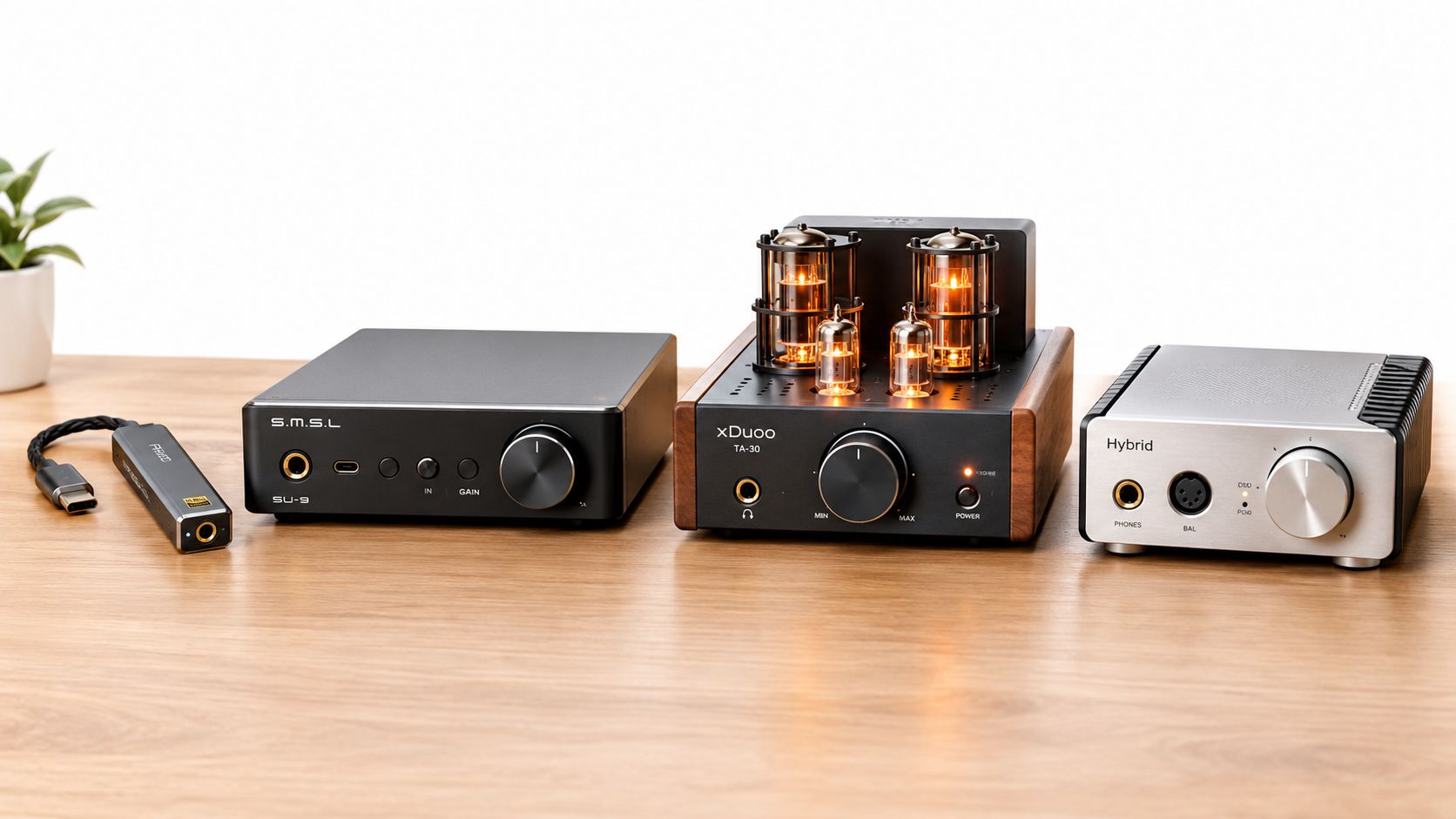 A collection of high-fidelity desktop audio equipment, including amplifiers and a DAC, resting on a wooden surface.